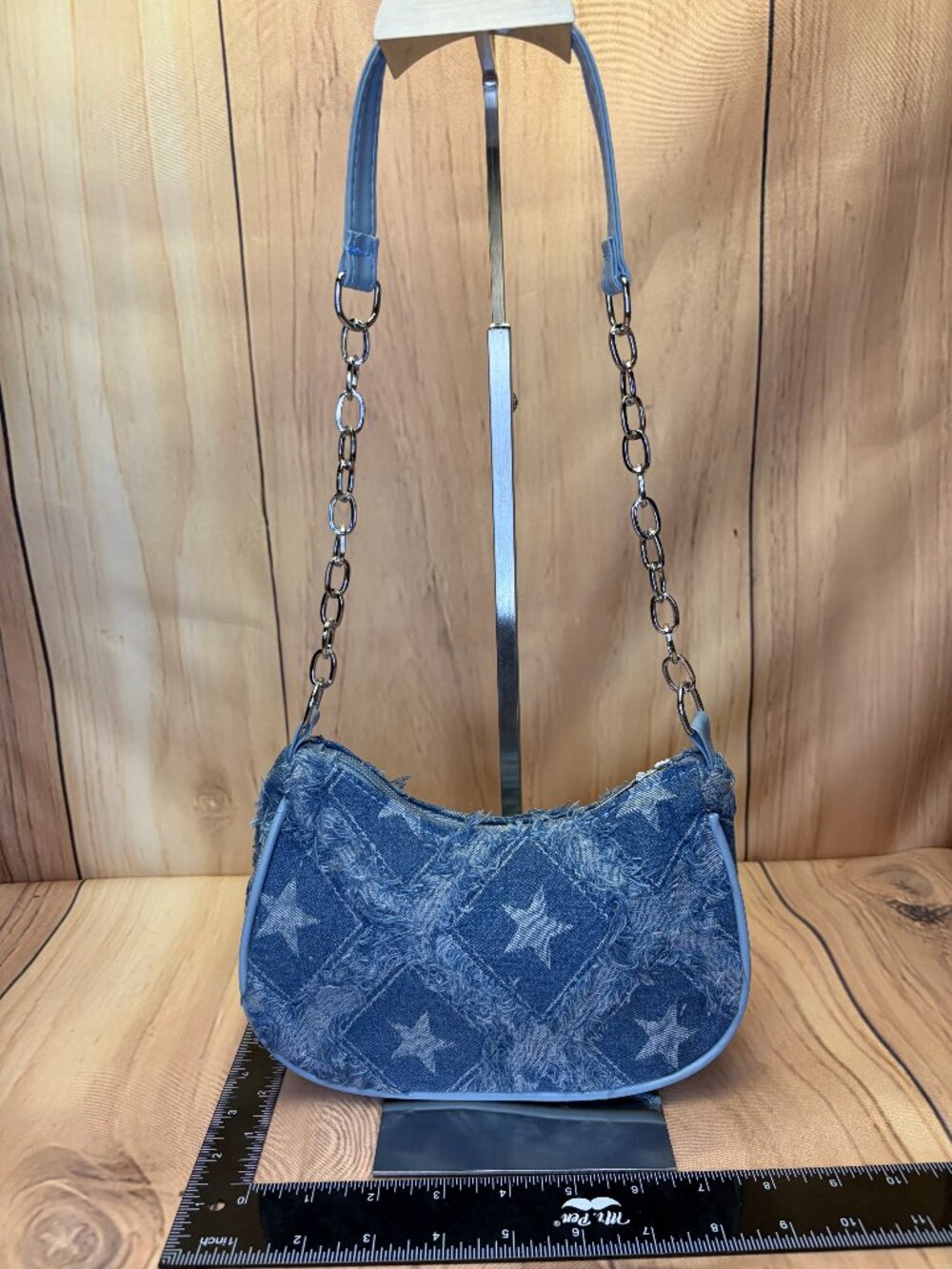 This is a blue denim shoulder bag featuring a frayed star-pattern patchwork